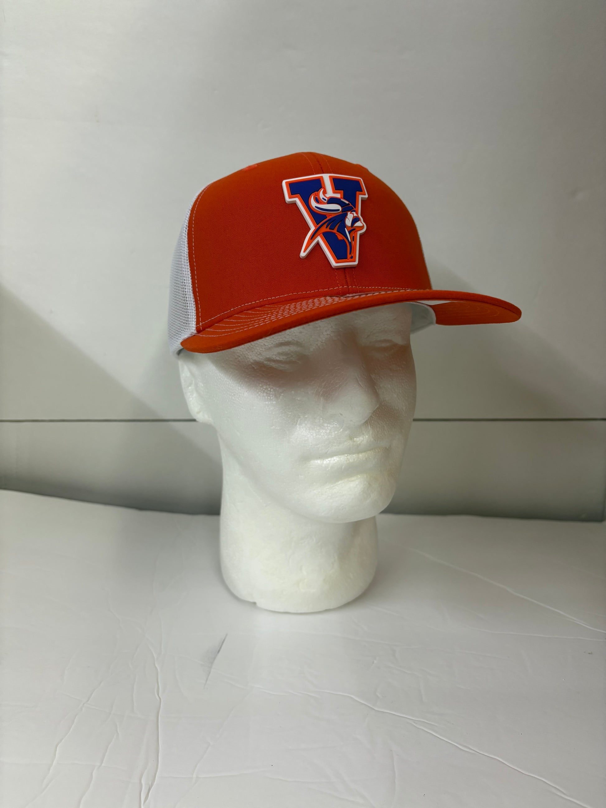 Orange Missouri valley college cap with a logo on a white mannequin head against a light gray background