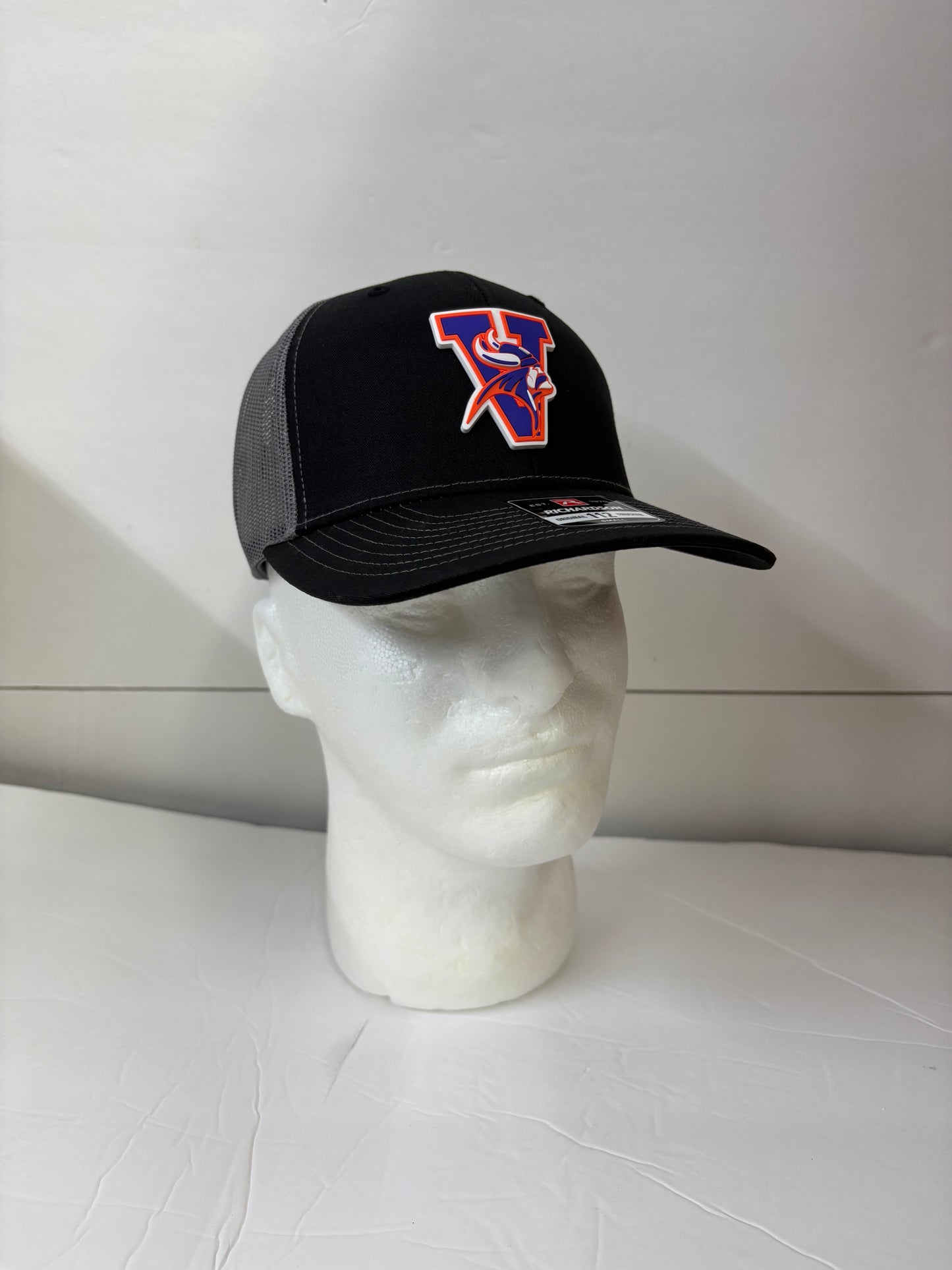 Black Missouri valley college cap with a logo on a white mannequin head against a white background